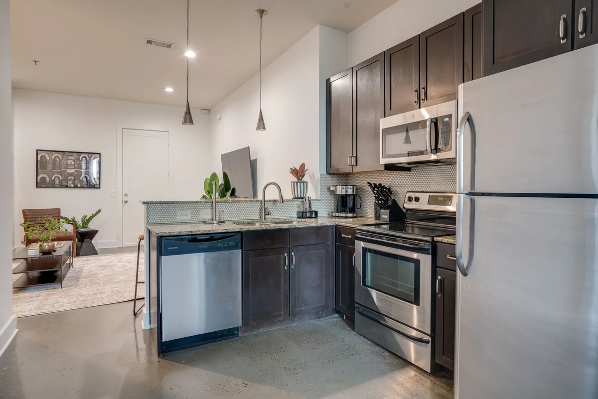 A welcoming and functional kitchen with visible appliances, ample countertop space, and stylish lighting fixtures. The ambiance is warm and suitable for both cooking and entertaining, echoing the sense of effortless meal prep and inviting gatherings.